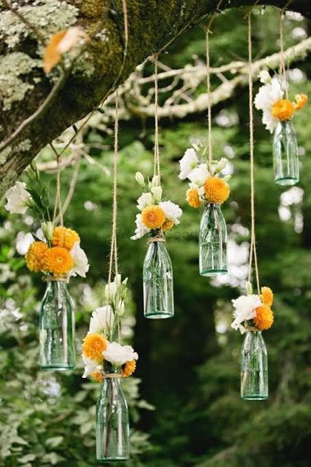 Hanging glass bottles filled with flowers.