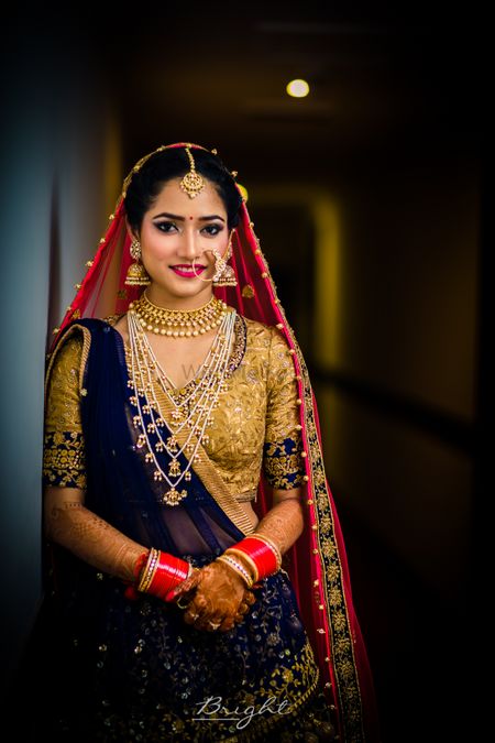 Photo of Bride in blue bridal lehenga with red dupatta and satlada