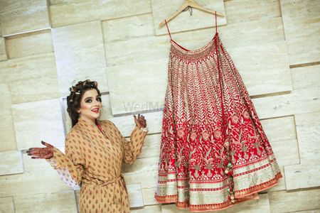 Bride with a Red Bridal Lehenga on a Hanger