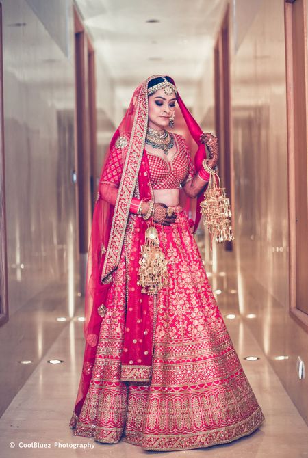 A bride in pink lehenga and golden kaleere