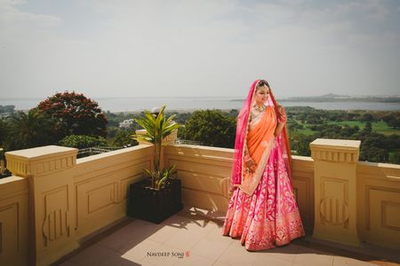 Photo of Bright benarasi bridal lehenga in orange and pink