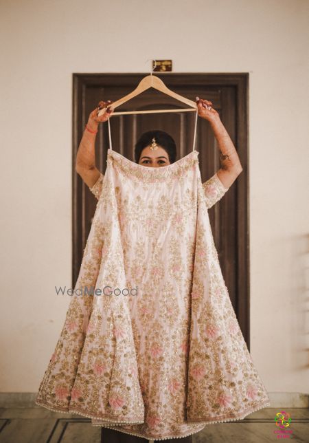 Bride holding lehenga on hanger 