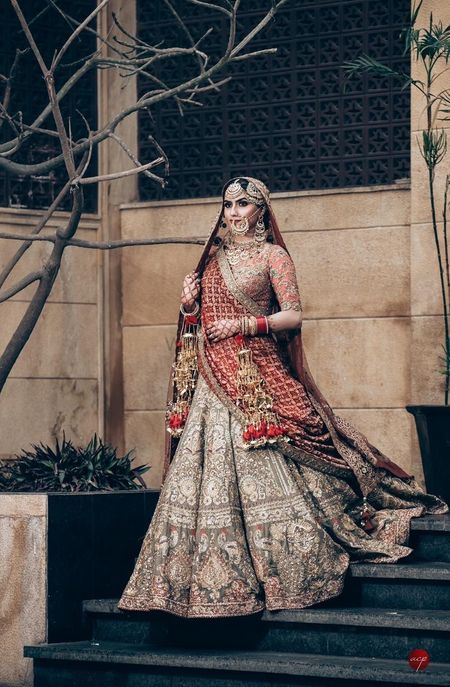 A Sikh bride in a metallic color lehenga wearing kaleere and antique jewellery