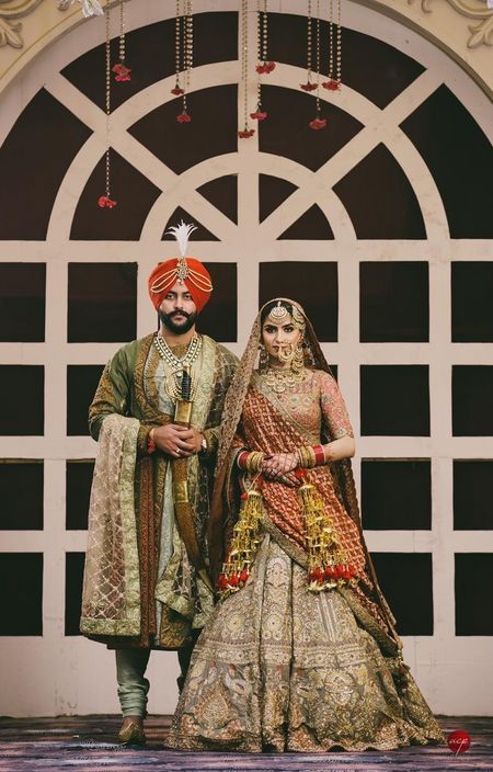 A sikh couple coordinates in royal outfits in metallic colors