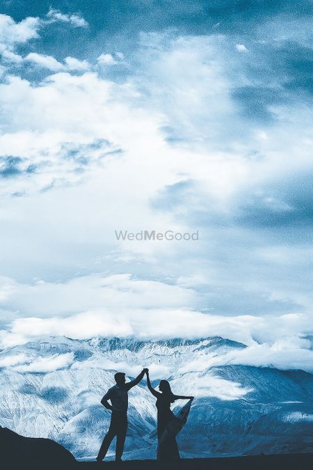 Photo of A couple pose on the hills for their pre wedding shoot