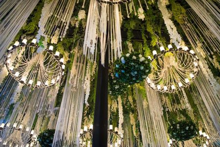 Photo of elegant hanging floral strings and chandeliers reception decor