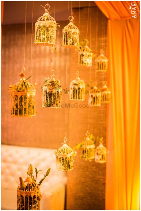 Suspended gold birdcages with foliage