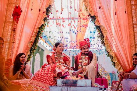 happy couple shot with mandap with peach drapes
