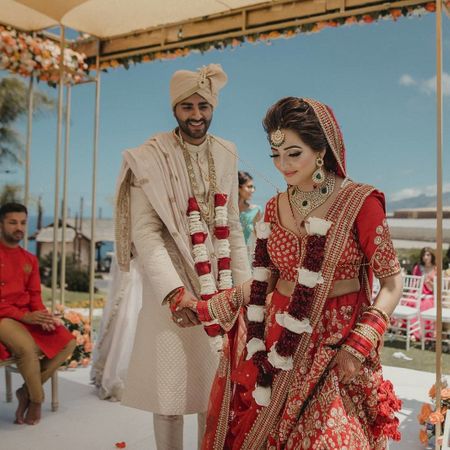 Photo of Candid shot of bride and groom taking pheras