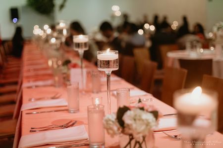 Photo of elegant table setting with candles and peach theme