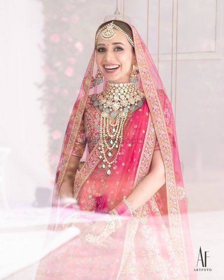 Photo of Bride wearing an elaborate choker with pink lehenga.