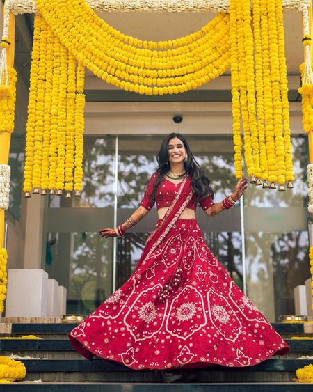 Photo of Bride twirling in her red lehenga.