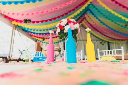 Photo of Multicolour matte painted bottles with flowers in decor