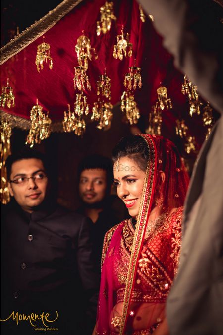 Bride entering under red phoolon ki chadar with kaleere