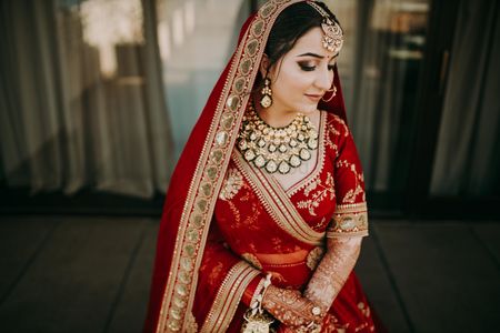A close up shot of a bride in red lehenga