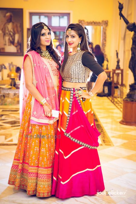 Bridesmaids in orange and pink lehengas