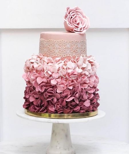 Photo of Two-tier fondant cake frosted with florals.