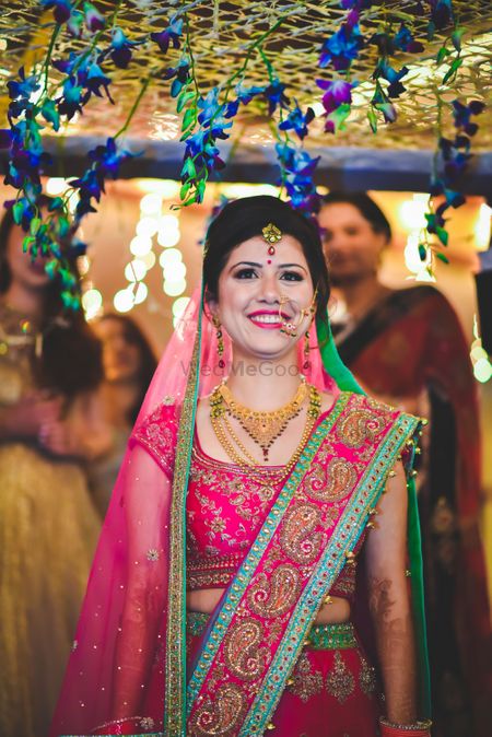 Bride in red lehenga with mint border and gold motifs