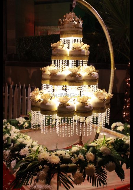 White hanging chandelier cake with smaller cakes