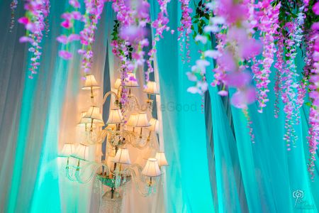 Hanging chandelier with blue curtains and purple floral
