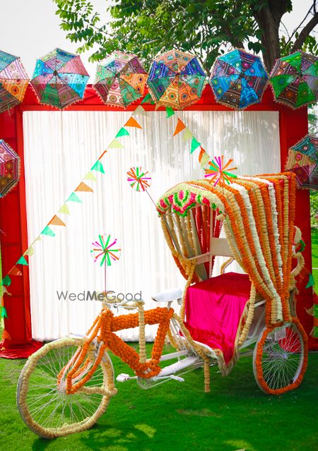 Colourful mehendi photobooth with decorated rikshaw