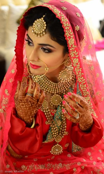 Photo of Bride in red and pink with gold finish jewellery