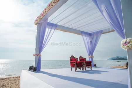 Mandap on beach with lilac drapes and white flowers