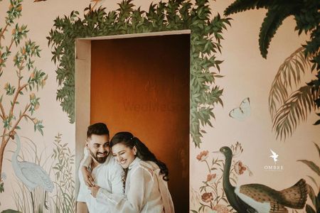 Photo of Couple posing against a beautifully hand-painted wall.