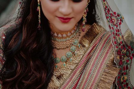 Photo of Bride wearing a choker with an enameled necklace.