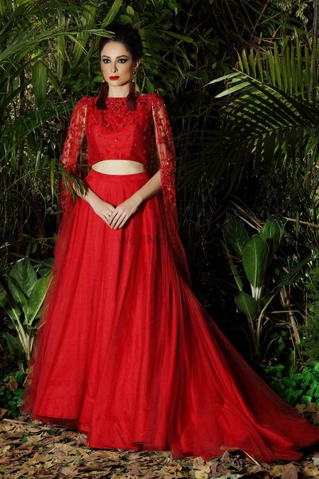 Bright red modern lehenga with lace cape and train