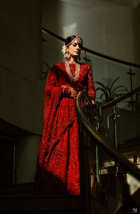 Bride dressed in a monotone red lehenga with contrasting jewellery.