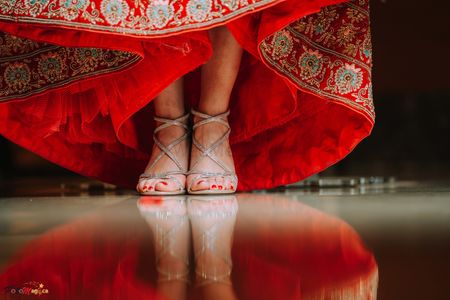 Photo of strappy silver bridal heals under red lehenga