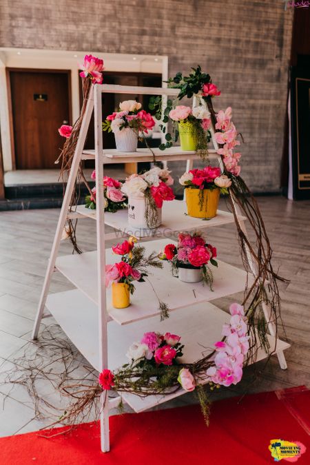 Ladder decorated with a bunch of floral centerpieces.