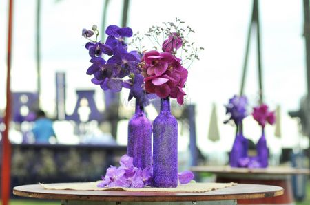 Purple bottle and flower centerpiece with flowers