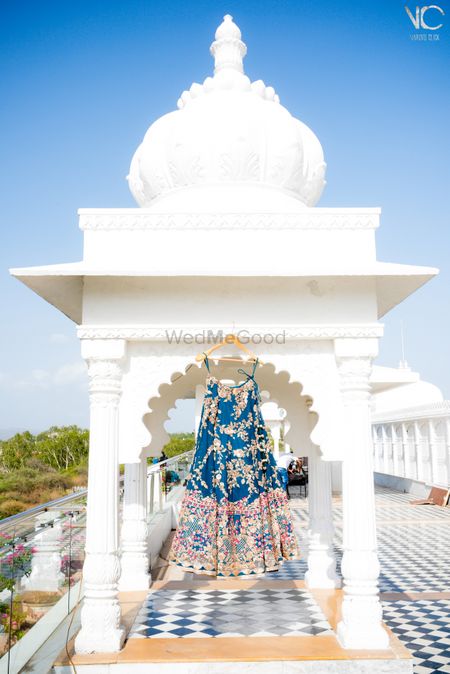 Photo of blue silk lehenga with floral leaf pattern going all over it and large intriicate border