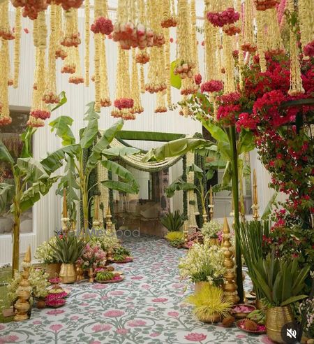 Gorgeous entrance decor for a home wedding with banana leaves and hanging florals