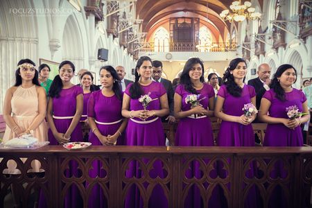 Photo of color co-ordinated bridesmaids wearing purple gowns