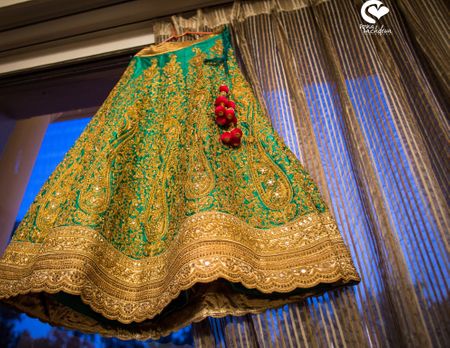 Green and gold lehenga on hanger in room