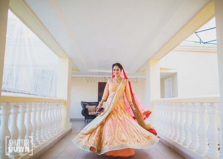 twirling bride shot in peach and gold lehenga