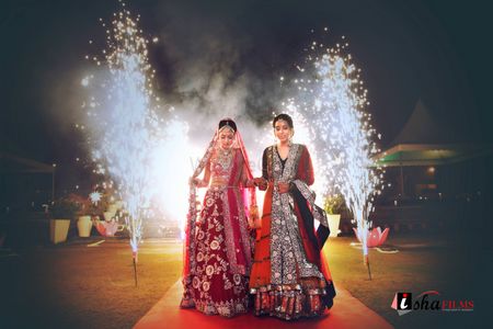 Dramatic bridal entry with sister with sparklers in the background