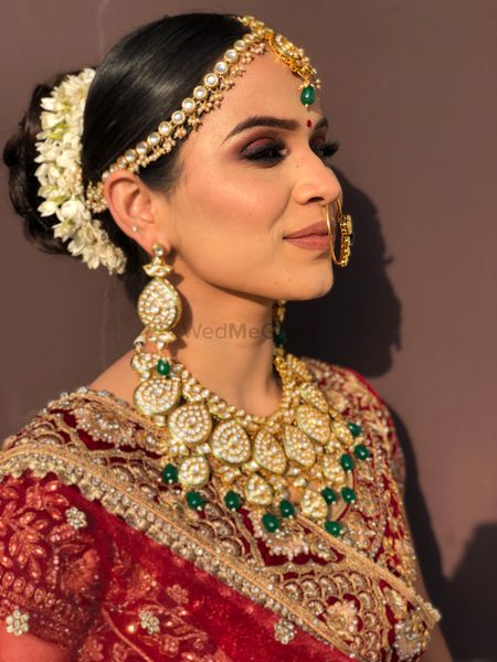 Bride wearing polki jewellery with her velvet lehenga.