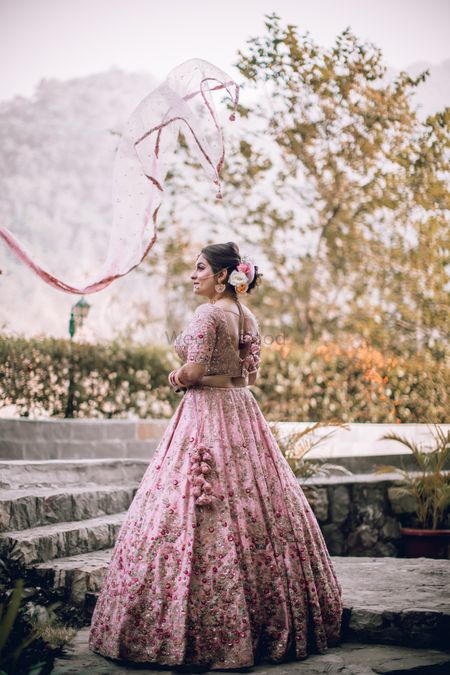 Photo of Bride dressed in a baby pink lehenga.