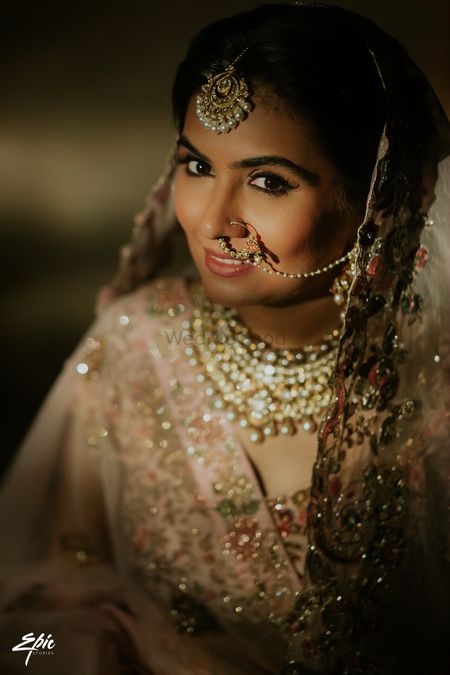 Bride wearing a pastel pink lehenga.