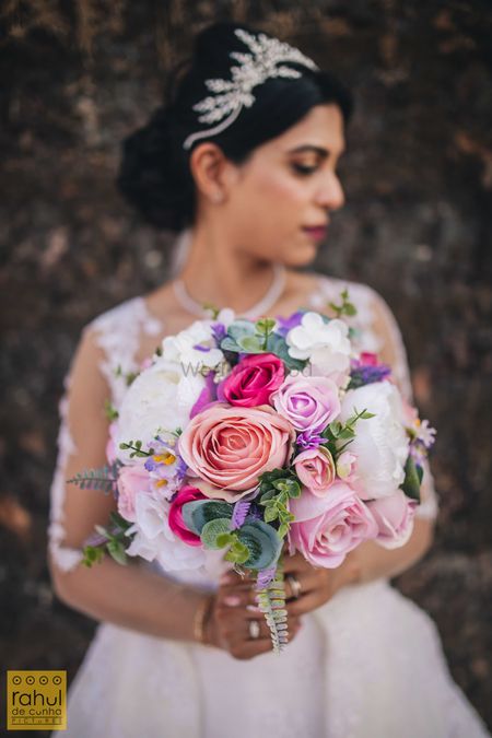 Photo of Bride holding a floral bouquet.