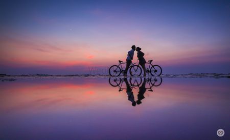 Pre wedding shoot with cycles on beach during sunset