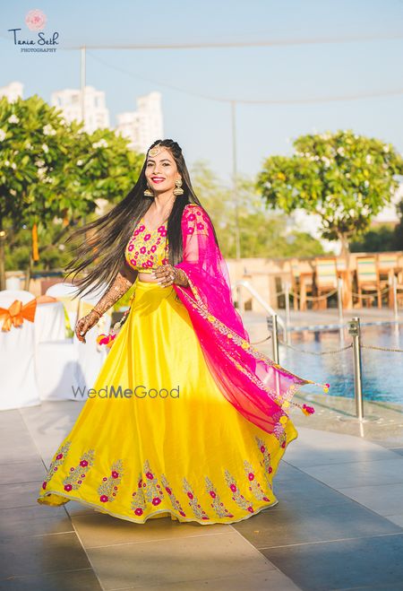 Photo of yellow and bright pink mehendi lehenga