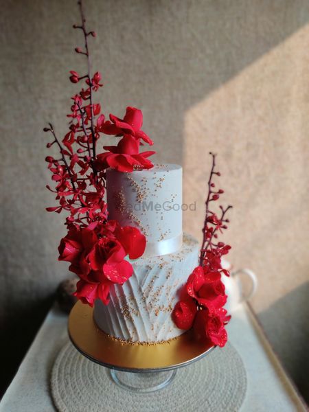Photo of Two-tier white wedding cake with flowers.