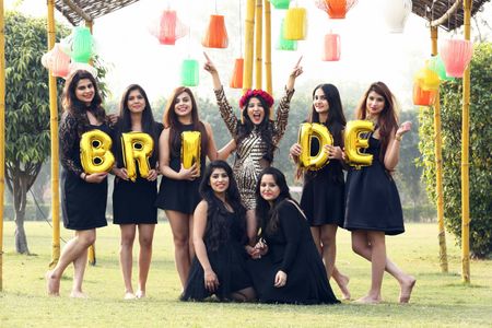 Photo of Bride with bridesmaids and bride balloons with black and gold theme