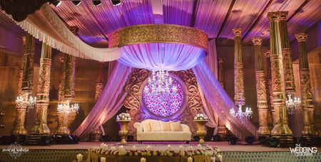 Photo of Opulent and grand stage decor in gold with pink flower wall