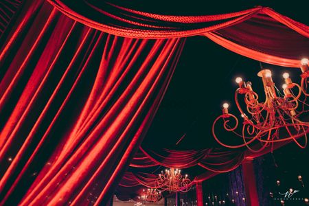 Glam red decor theme with wrought iron chandeliers